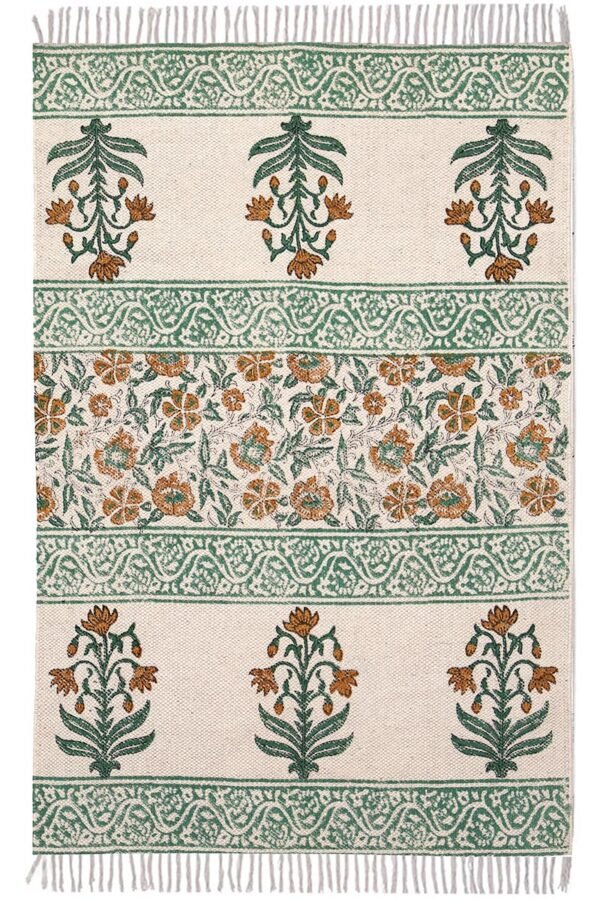 Overhead view of an elegant floral washable cotton rug featuring green and terracotta botanical motifs on a cream base. Close-up of the knotted fringe detail and sage green patterned border on a flatweave washable cotton rug. Botanical print washable cotton rug with an Indian-inspired block print design laid flat on a hardwood floor.